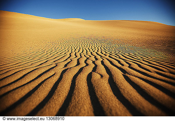 Sand dunes against clear sky