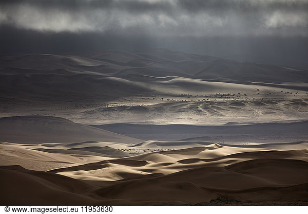 Sand dunes under a stormy sky.