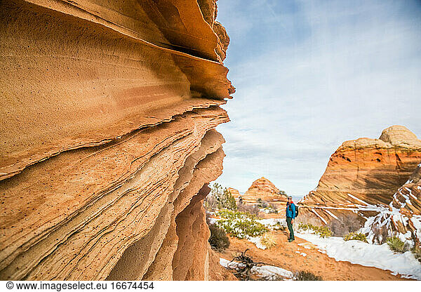 Sandstone lace rock and hiker for scale  Vermilion Cliffs