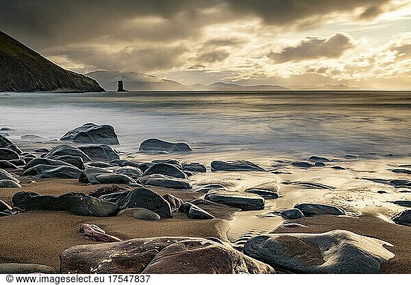 Sandstrand mit Steinen an Nordatlantik mit Felsnadel und Wolkenhimmel  Halbinsel Dingle  Kerry  Irland  Europa
