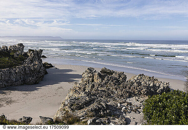 Sandstrand und Felsformationen Blick von oben Wellen die sich am Ufer brechen.