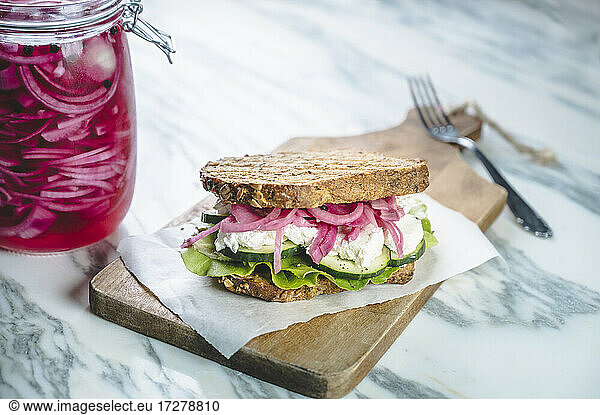 Sandwich with pickled onions  cucumbers  creamed goat cheese and lettuce