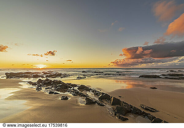 Sandy coastal beach at moody sunrise