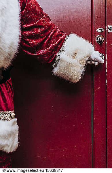 Santa Claus gloved hands open the door,  close up