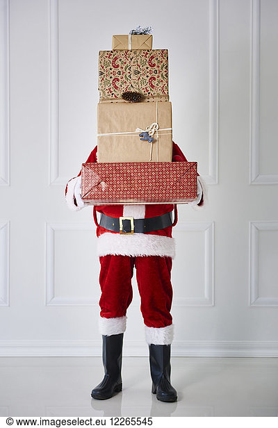 Santa Claus holding stack of Christmas presents
