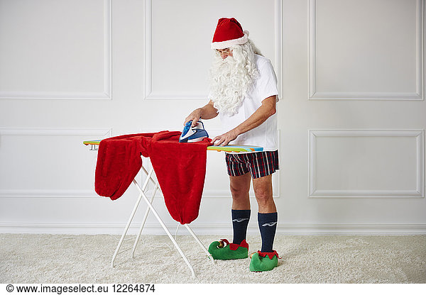 Santa claus ironing his pants