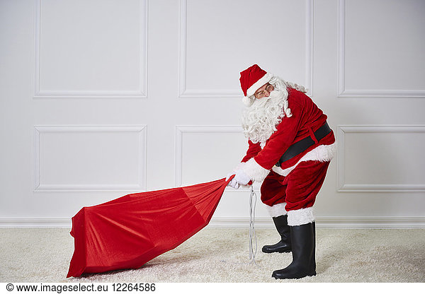 Santa claus pulling heavy sack