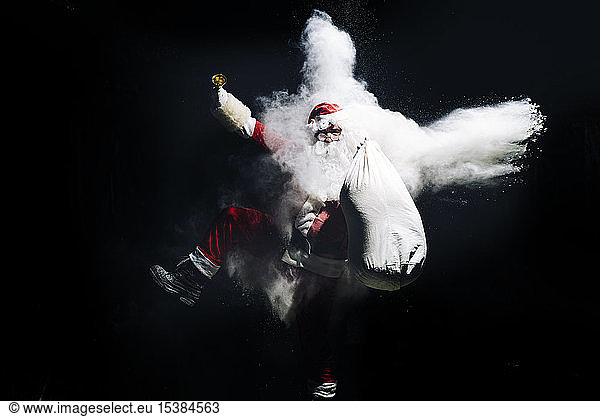 Santa Claus with exploding snow bomb against black background