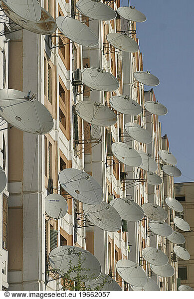 Satellite dishes on the side of an apartment block