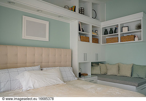 Sauberes  modernes Schlafzimmer mit Regalen und Leseeckenbank
