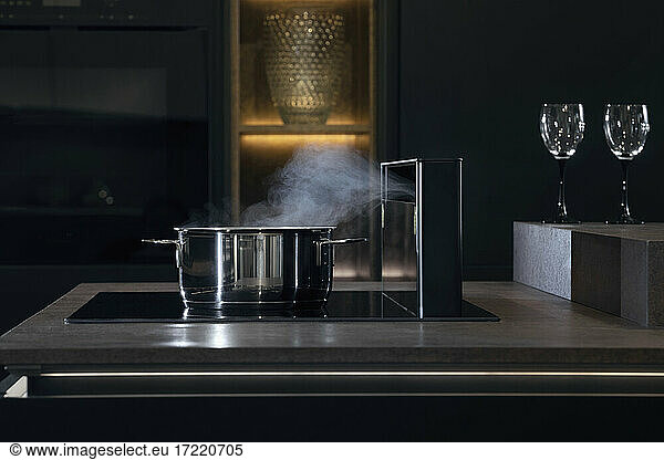 Saucepan with steam on stove in kitchen
