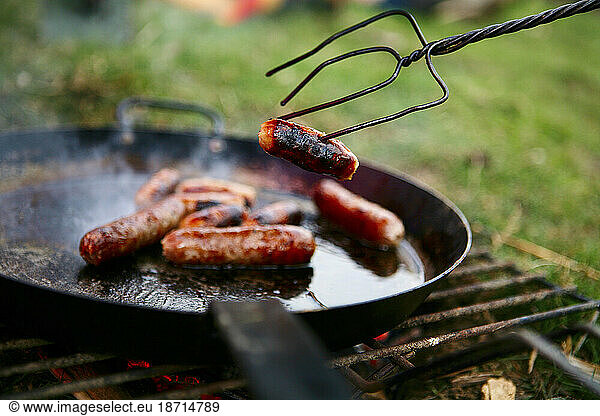 Sausages are being grilled on camp fire at a fun family day out near Ellingstring  North Yorkshire  England  UK  on March 22 2009.