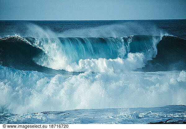 Scenic view of a big wave breaking in the sea against clear sky