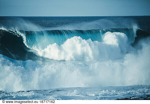 Scenic view of a big wave breaking in the sea against clear sky