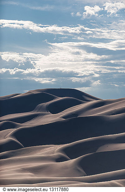 Scenic view of desert against cloudy sky at Great Sand Dunes National Park