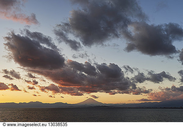 Scenic view of Honshu island by Mount Fuji against sky during sunset