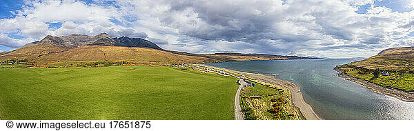 Scenic view of lake and Cuillin mountains under cloudy sky