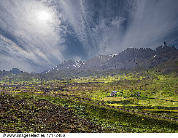 Scenic view of landscape with homestead against mountain and sky