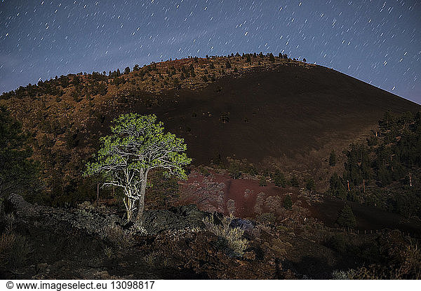Scenic view of mountain against star trails at Sunset Crater Volcano National Monument
