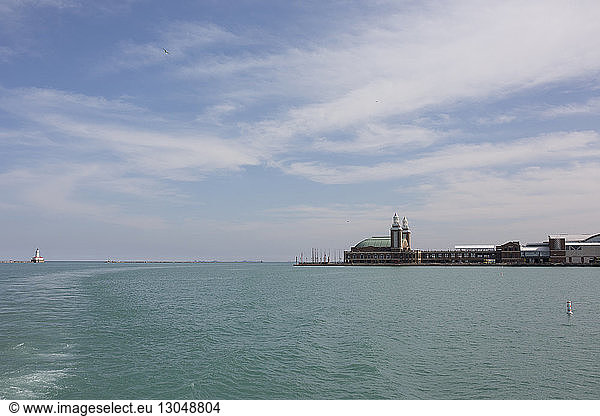 Scenic view of Navy Pier over Lake Michigan against cloudy sky