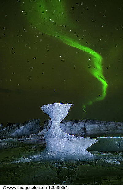 Scenic view of northern lights over icebergs
