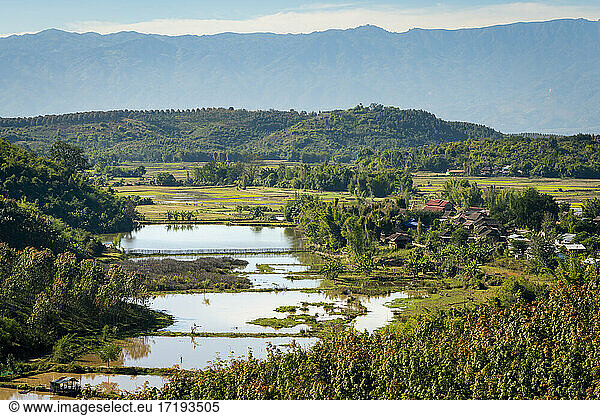 Scenic view of remote village next to flooded rice field  near Kengtung  Myanmar