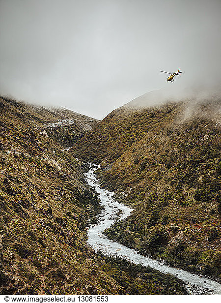 Scenic view of river amidst mountains against cloudy sky at Sagarmatha National Park