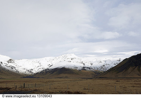 Scenic view of snowcapped mountain against cloudy sky at Iceland