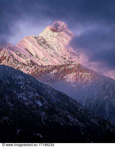 Scenic view of snowcapped mountain against cloudy sky during sunset