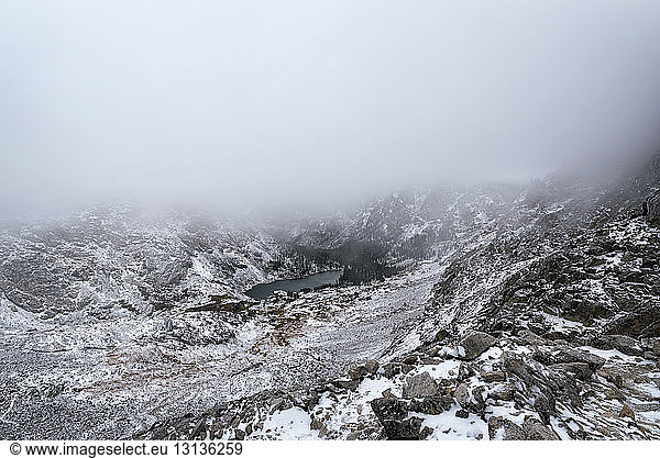 Scenic view of snowcapped mountain during foggy weather