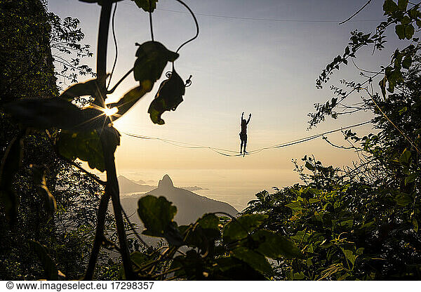 Schöne Aussicht auf männliche Highliner Silhouette auf Berg Sonnenaufgang