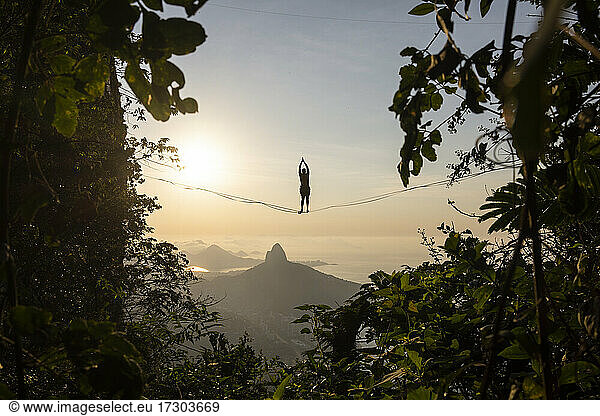 Schöne Aussicht auf männliche Highliner Silhouette auf Berg Sonnenaufgang