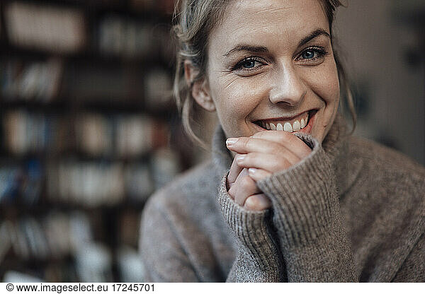 Schöne Frau im Pullover lächelnd im Café