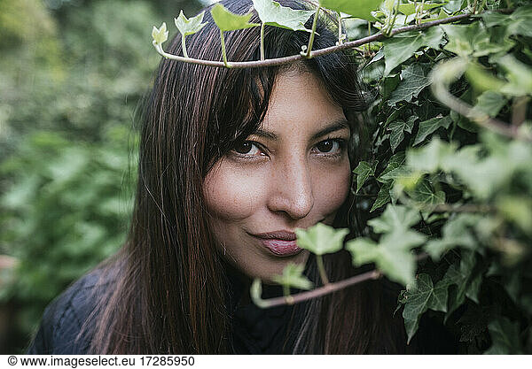 Schöne Frau schaut durch Zweige