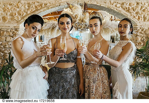 Schöne Frauen halten Champagnerflöte beim Stehen beim Bankett