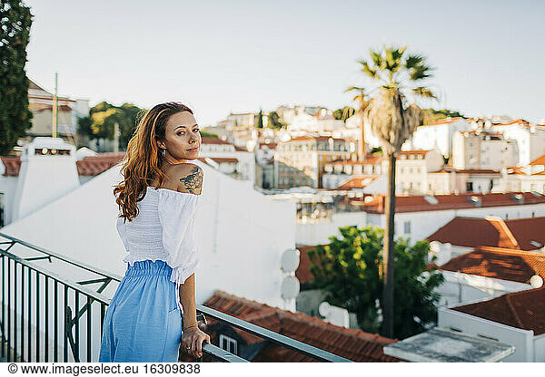 Schöne junge Frau lehnt am Geländer der Alfama  Lissabon  Portugal