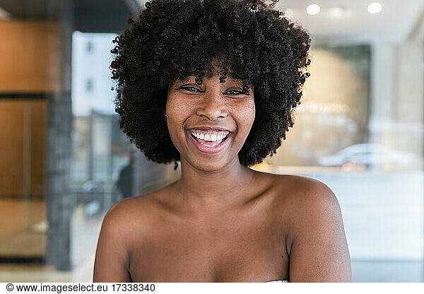Schöne junge Frau mit Afrofrisur lachend