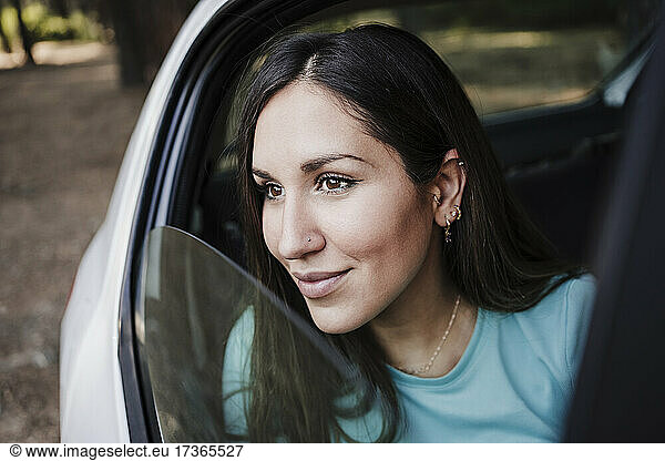 Schöne junge Frau schaut durch ein Autofenster