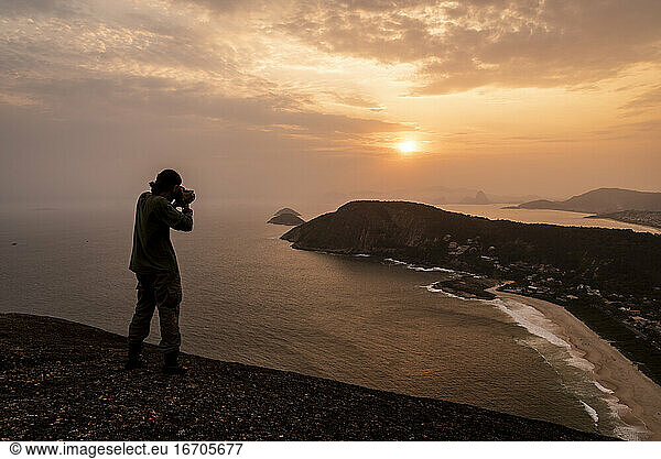 Schöner Blick auf den Sonnenuntergang zum Abenteuer Fotograf auf dem Hügel