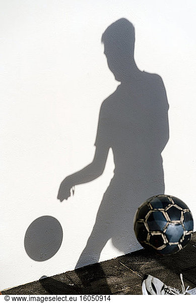 Schatten eines Mannes  der mit Fußball trainiert