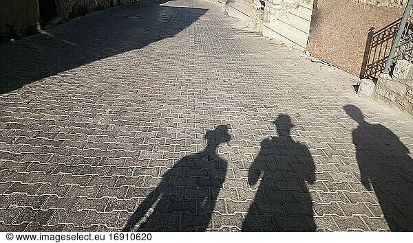 Schatten von drei Personen auf dem Boden in der Stadt mit Kopierraum.