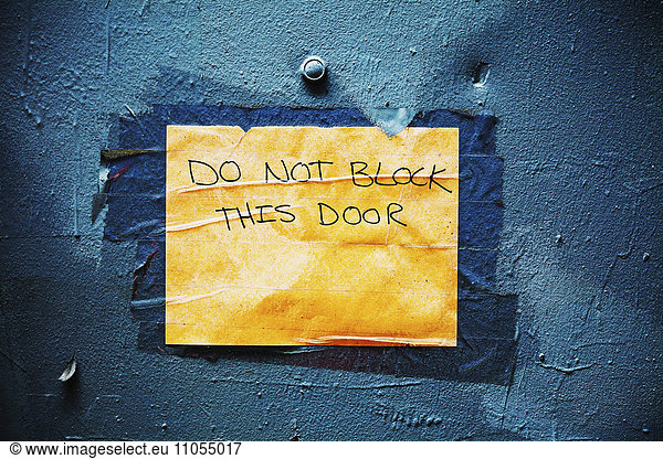 Schild an einer blauen Tür nicht blockieren