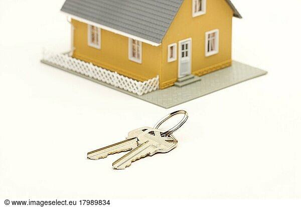 Schlüssel und Haus vor weißem Hintergrund. Fokus liegt auf den Schlüsseln