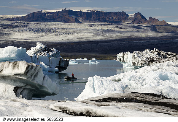 Schlauchboot oder Zodiac Boot  von Asche teils schwarz gefärbte Eisberge  Gletscherlagune Jökuls·rlÛn  Vatnajökull Gletscher  Austurland  Ost-Island  Island  Europa