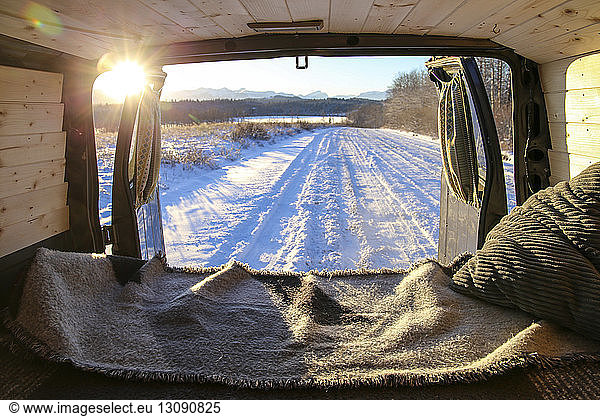 Schneebedeckte Landschaft durch Fahrzeug bei Sonnenuntergang gesehen