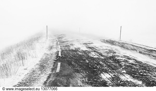 Schneebedeckte Straße bei nebligem Wetter