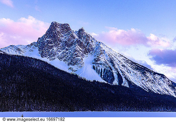 Schneebedeckter Berg bei Sonnenuntergang in den verschneiten kanadischen Rocky Mountains.