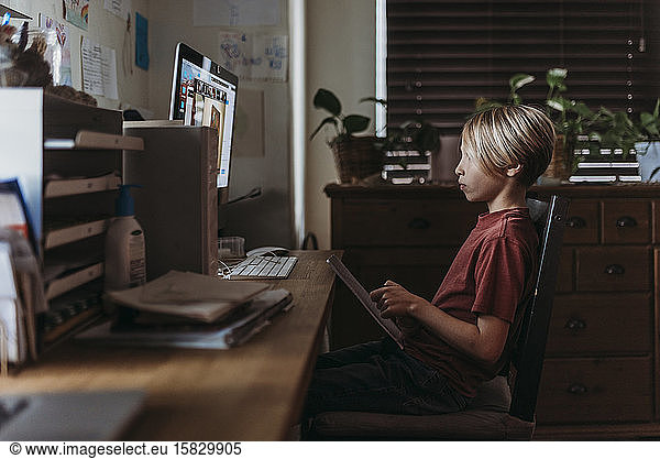 School aged boy learning online by video chat during homeschool
