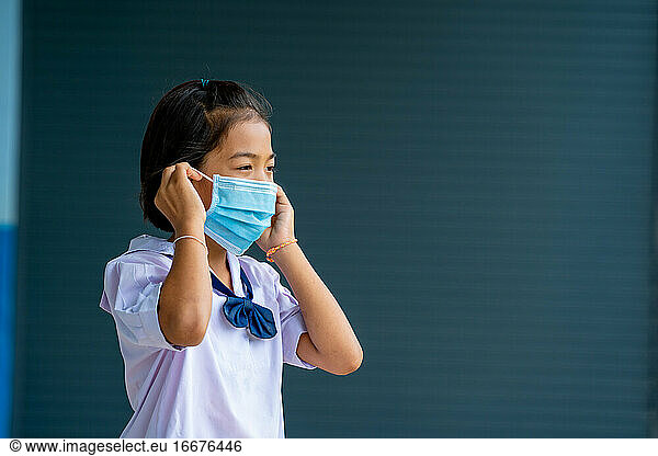 School kids wearing medical mask or surgical mask to protect her