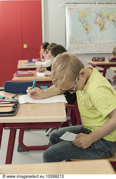 Schoolboy cheating on a test in classroom  Munich  Bavaria  Germany